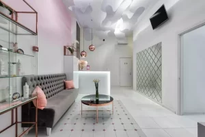 esempio arredamento sala d'aspetto di un centro estetico con divano, cuscini, luci e vetrina esposizione prodotti