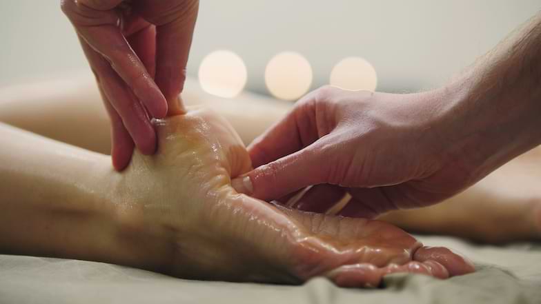 esecuzione di massaggio ayurvedico ai piedi con applicazione di oli ayurvedici